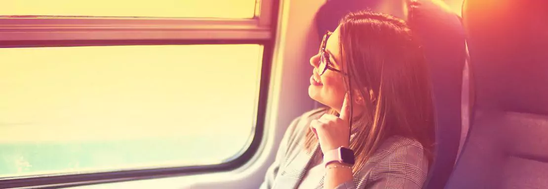 Femme pensive regardant par la fenêtre du train