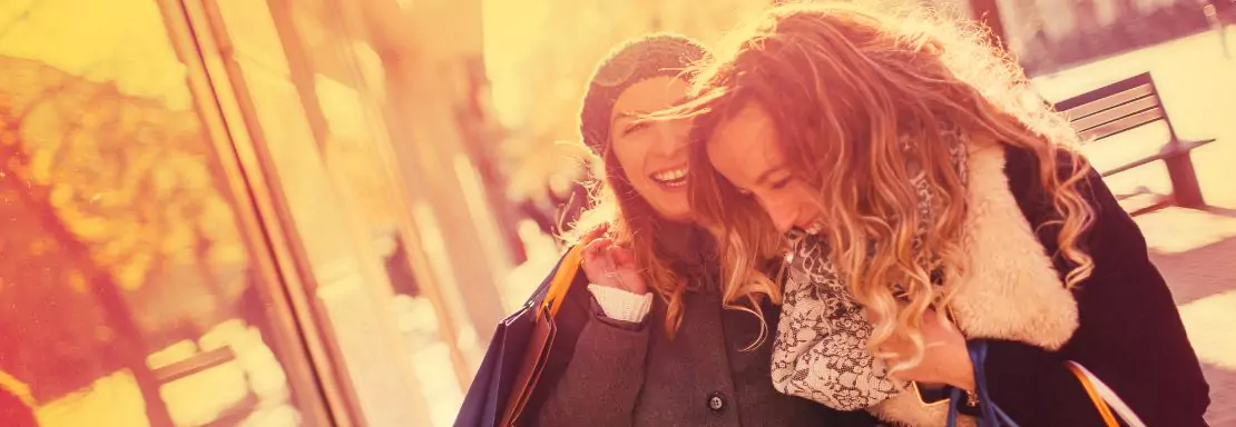 Deux femmes souriantes font du shopping en plein air