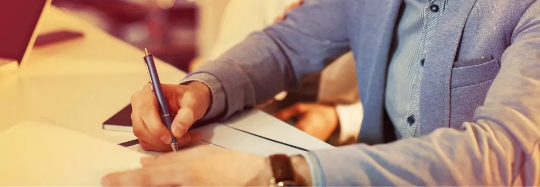 Homme prenant des notes en réunion d'affaires