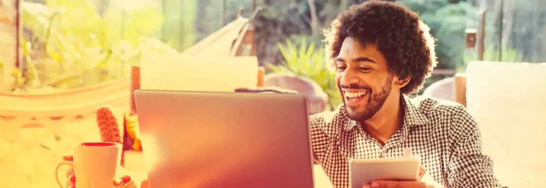 Homme travaillant heureux sur un ordinateur dans un espace vert