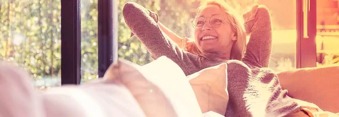 Femme heureuse se relaxant sur un canapé