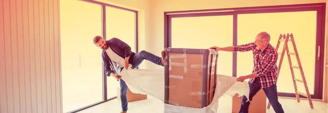 Deux hommes déballent un carton dans un appartement