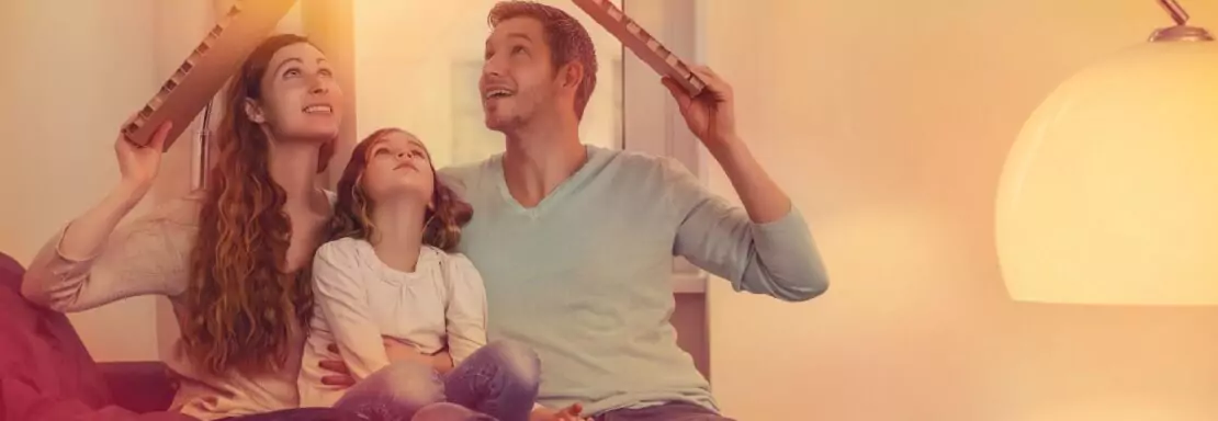 Famille créant un symbole de maison avec des planches en bois