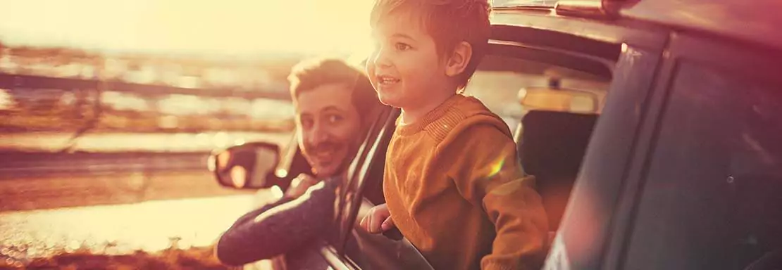 Père et fils regardant par la fenêtre d'une voiture