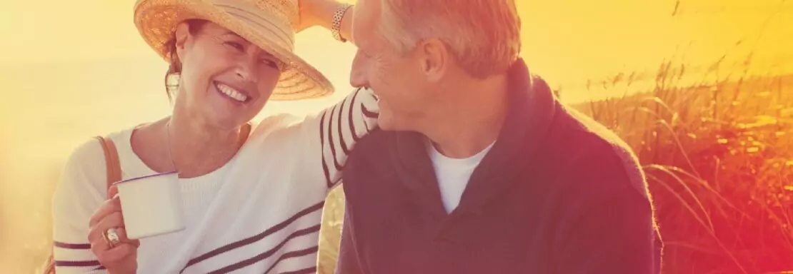 Couple souriant profitant du coucher de coleil en plain air
