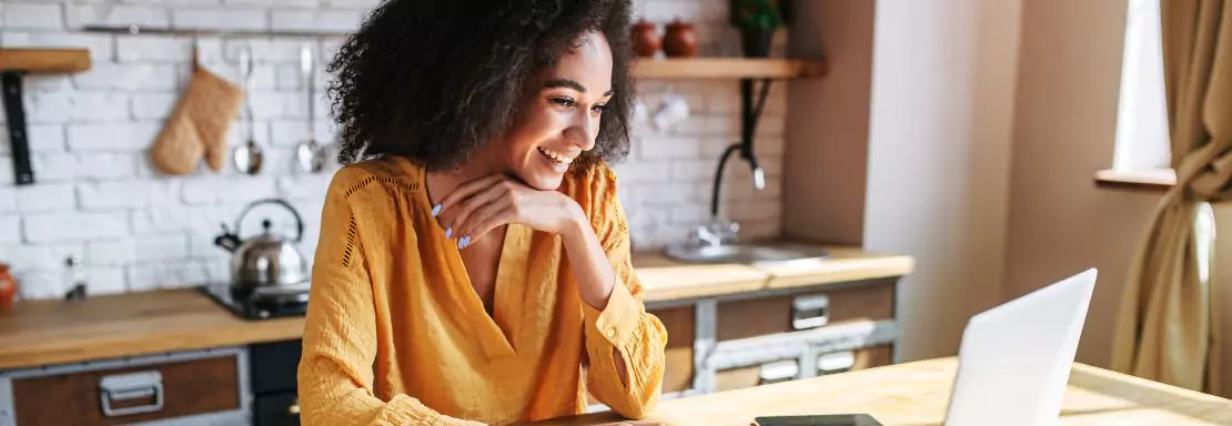 Femme souriante qui travaille sur un ordinateur portable