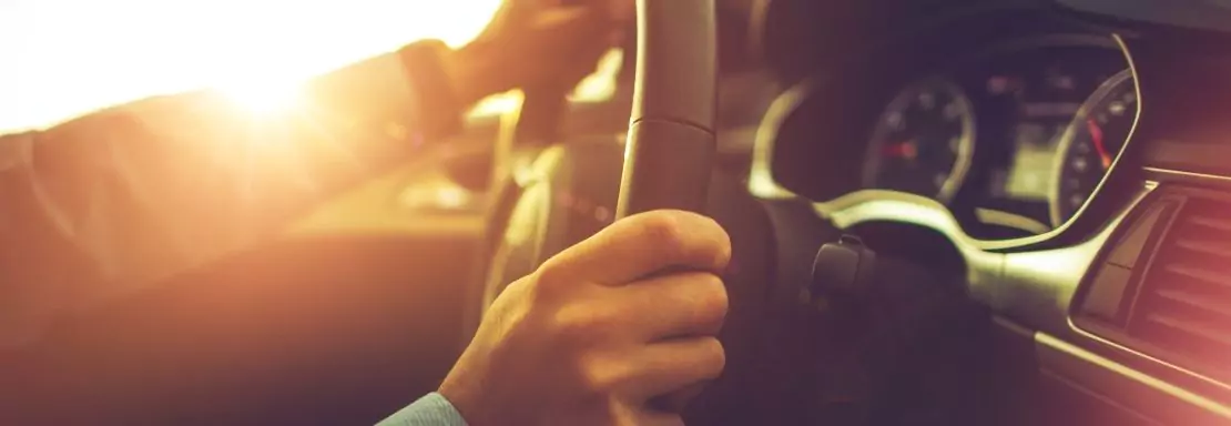 Personne conduisant voiture au coucher de soleil