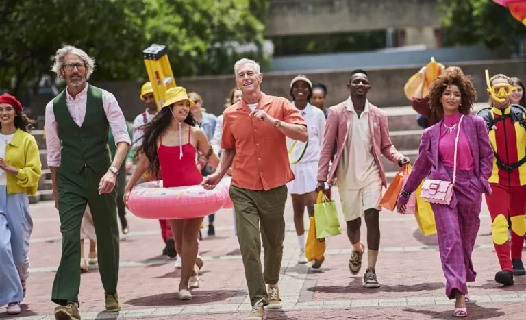 Un groupe de personnes souriantes marche ensemble en extérieur