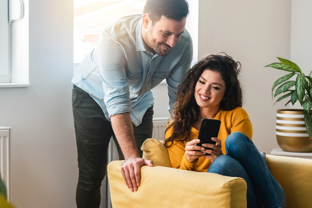 Une femme et un homme regardent ensemble l'écran d'un smartphone