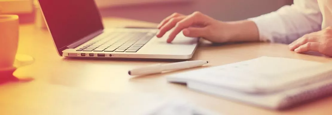 Persoon aan het werk op laptop bij bureau