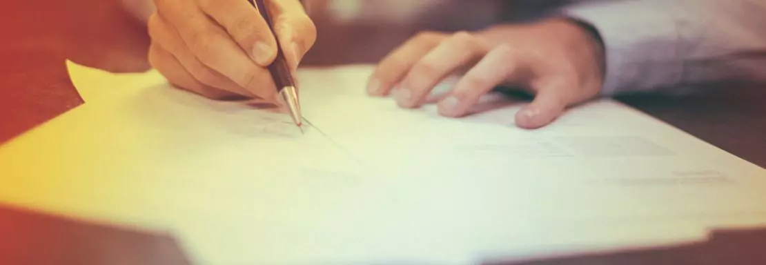 Hand schrijft op document met pen