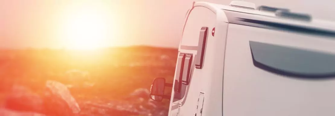 Caravan bij zonsondergang in een rustgevend landschap
