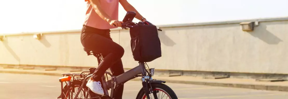 Vrouw die op een elektrische fiets rijdt op een zonnige dag