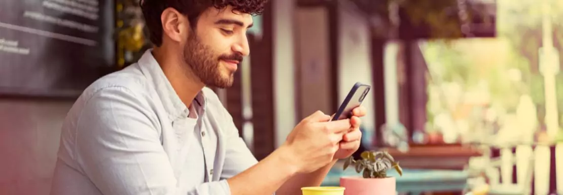 Man gebruikt smartphone buiten op zonnige dag