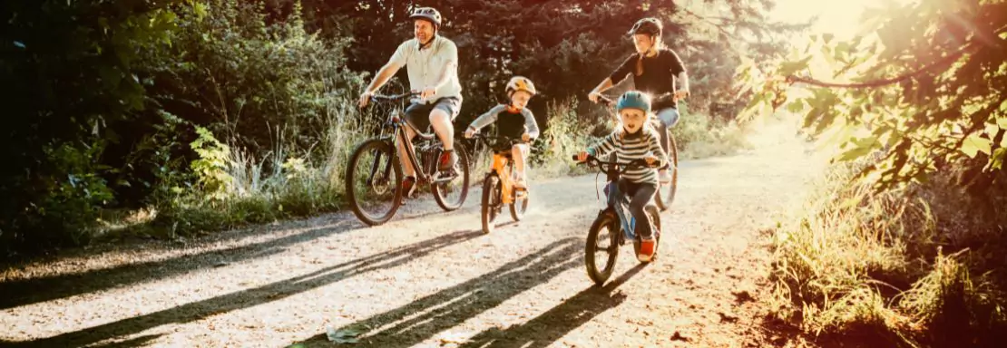Gezin fietst samen op een zonnige bosweg